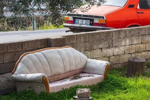 Side Turkey  February 20 2022   close up of an old dirty sofa stands on the street next to the road photo