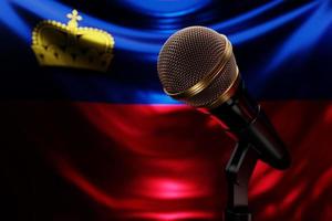 Microphone on the background of the National Flag of Liechtenstein , realistic 3d illustration. music award, karaoke, radio and recording studio sound equipment photo