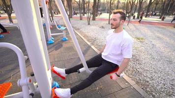 man aan het sporten in het park. man die sport doet met sportuitrusting in het park, beenoefeningen. video