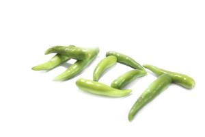 Fresh large green chillies cultivated by farmers for sale and self-eating - for seasoning and appetizing food on a white background with local hot letters. photo