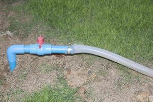 Water valves and watering hoses on the growing green lawn in the backyard. photo