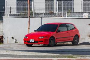 lado turquía 28 de febrero de 2022 el honda civic rojo está estacionado en la calle en un cálido día de verano contra el edificio foto