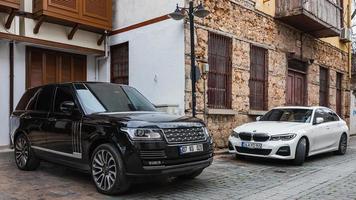 Side Turkey  February 20 2022 black Land Rover Range Rover and BMW 5 series is parked  on the street on a warm day photo