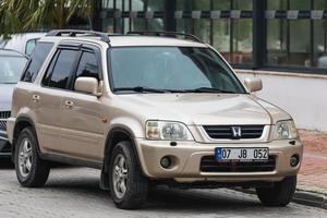 lado pavo 04 de marzo de 2022 beige honda cr v está estacionado en la calle en un cálido día de verano contra el estacionamiento foto