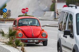 lado turquía 20 de febrero de 2022 escarabajo volkswagen de coche rojo vintage en el fondo de una calle de la ciudad, vista frontal. coche retro legendario en un entorno urbano foto