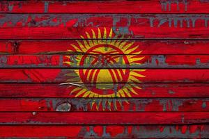 The national flag of Kyrgyzstan  is painted on uneven boards. Country symbol. photo