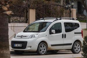 Side Turkey  February 23 , 2022   white Fiat Fiorino is parking  on the street on a  summer day against the backdrop of a shop , park photo