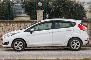 Side  Turkey  February  20, 2022 white  Ford Fiesta   is parked  on the street on a warm day against the backdrop of a buildung,   park photo