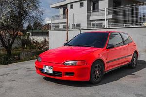 lado turquía 28 de febrero de 2022 el honda civic rojo está estacionado en la calle en un cálido día de verano contra el edificio foto