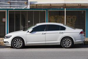 lado turquía 18 de febrero de 2022 volkswagen passat blanco está estacionado en la calle en un cálido día de otoño con el telón de fondo de una calle, tienda foto