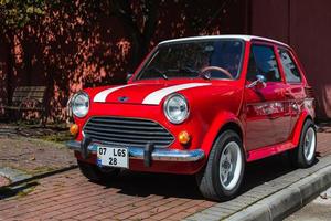 lado pavo 01 de marzo de 2022 mini cooper rojo está estacionando en la calle en un día de verano. cooper vehiculo retro foto