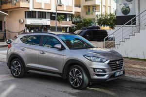 Side Turkey  February 20 2022 silver Hyundai Tucson  is parked  on the street on a warm day against the backdrop of a shops photo