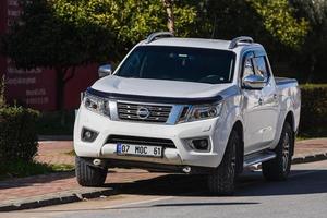 lado turquía 01 de marzo de 2022 blanco nissan navara está estacionando en la calle en un día de verano con el telón de fondo de un parque foto