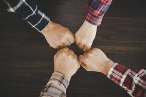 jóvenes empresarios poniendo sus manos juntas foto