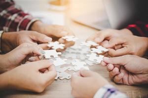 Business people and puzzle on wooden table photo