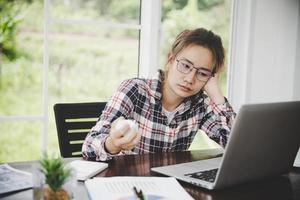 mujer de negocios cansada trabajando en una computadora foto