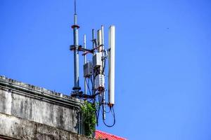 Devices and Receivers Communication Signal with antennas on the top of building and bright blue sky background. photo