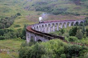 A view of the Glenfinnan Viaduct showing a Steam Train passing over it photo
