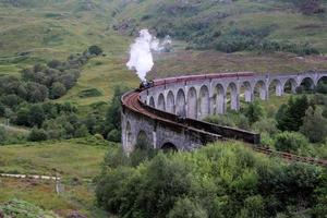 A view of the Glenfinnan Viaduct showing a Steam Train passing over it photo