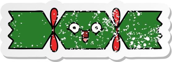 distressed sticker of a cute cartoon christmas cracker vector