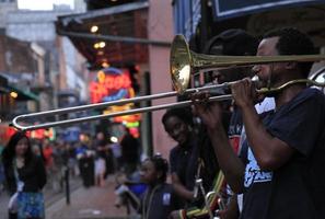 12 de abril de 2015 - nueva orleans, luisiana, estados unidos - músicos de jazz actuando en el barrio francés de nueva orleans, luisiana, con multitudes y luces de neón en el fondo. foto