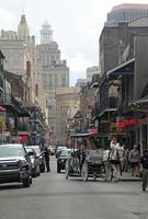 12 April 2018 - New Orleans, Louisiana, United States - Street scene in the French Quarter of New Orleans, Louisiana, with the higher downtown buildings in the background. photo
