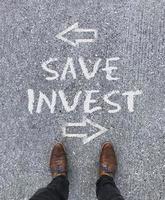 Top view on the words Save and Invest with arrows pointing left and right photo