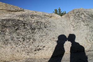 Shadow of a young couple kissing on a rock in Yosemite national park photo