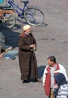 marrakech, marruecos - 12 de septiembre de 2018 - un hombre vestido con ropa tradicional sosteniendo su serpiente mascota en una plaza de la ciudad de marrakech, marruecos. foto