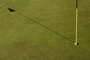 Golf course with flag stick on a sunny day photo