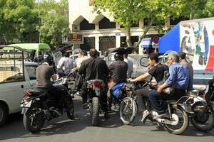 Tehran, Iran - June 12, 2019 - Busy traffic with many motorbikes in the streets of Tehran, Iran. Tehran is rated as one of the world's most polluted cities and traffic is a key contributor. photo