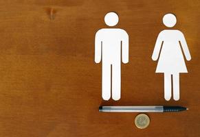 Gender equality - Overcoming the pay gap. Male and female symbol balancing on Euro coin photo