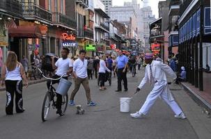 12 April 2018 - New Orleans, Louisiana, United States - Street artist during his performance in the French Quarter of New Orleans, Louisiana, with crowds and neon lights in the background. photo