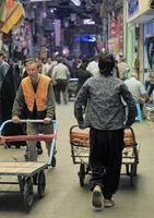 Tehran, Iran - June 10, 2018 - Workers push pushcarts through the busy bazaar in Tehran, Iran. photo