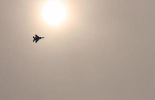 Fighter jet flying past the sun in Japan photo