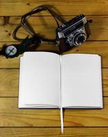 An empty travel journal with old-fashioned camera and compass photo