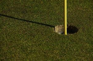 Close-up of hole and flag stick on a golf course photo