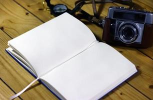 An empty travel journal with old-fashioned camera and compass photo