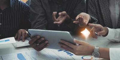 Group of business people meeting together Pointing to the graph assess business profits. photo