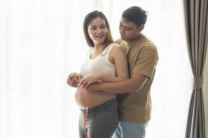 mujer joven embarazada que mide el centímetro del vientre, atención médica y atención del embarazo foto