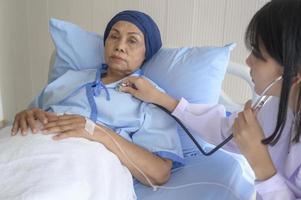 Cancer patient woman wearing head scarf after chemotherapy consulting and visiting doctor in hospital.. photo