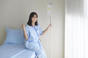 Hopeful and happy young patient woman in hospital, healthcare and medical concept photo