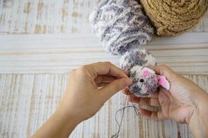 Woman making lovely bunny doll from yarn  - Easter holiday celebration concept photo