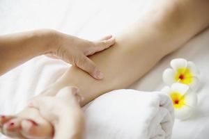 Woman receiving foot massage service from masseuse close up at hand and foot - relax in foot massage therapy service concept photo