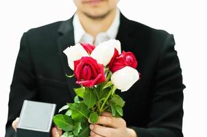 Man giving red and white bouquet roses and gift box to somebody with white background in valentine day or other love festival event - romance love celebration concept photo