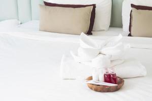 Hotel towel set with toothbrush and toothpaste on white bed photo