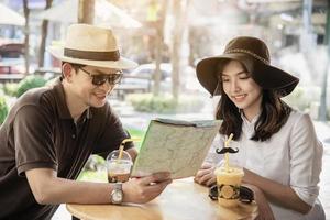 Asian couple enjoy traveling sitting at coffee shop - happy young people on vacation concept photo