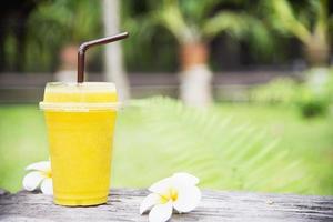 Ice mango orange blend in green garden - relax with cold fruit drink in nature concept photo