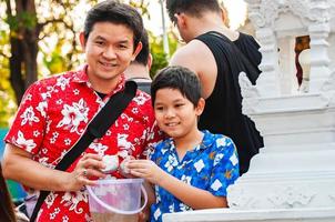 Thai family participate old traditional activity in a temple during Songkran festival in Chiang Mai Northern Thailand very famous event of Thailand photo