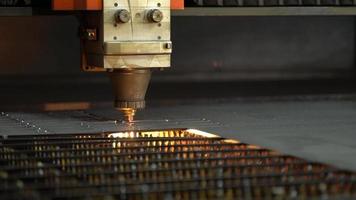 CNC laser cutting machine.  The metal sheet is cut on the cnc machine and holes are drilled on it. Laser cutting device following laser light and laser light. video